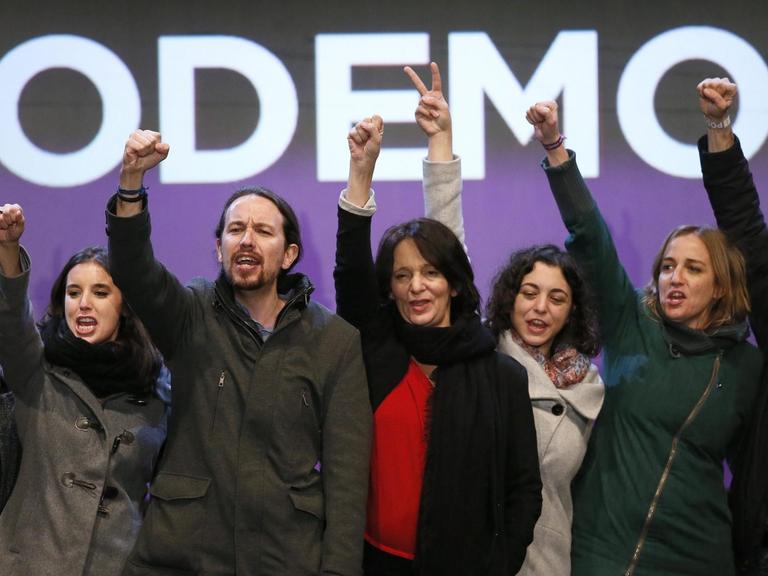 Zu sehen in einer Reihe sind Mitglieder der Partei "Podemos", die ihre Arme in die Luft recken. Auch Parteichef Pablo Iglesias ist dabei (dritter von links).