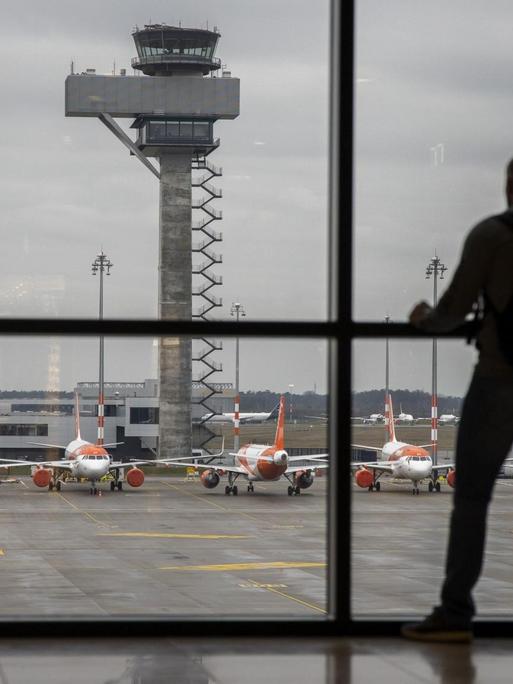 Ein Fluggast im Wartebereich des Terminals vom Flughafen Berlin-Brandenburg.