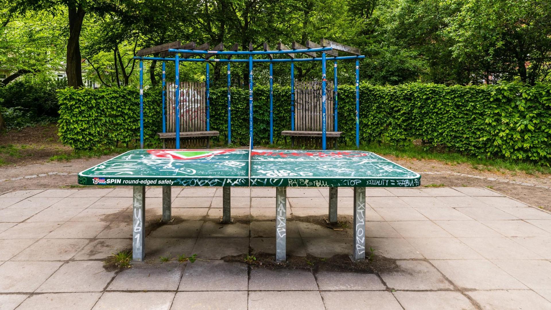 Eine Tischtennisplatte auf einem Spielplatz.