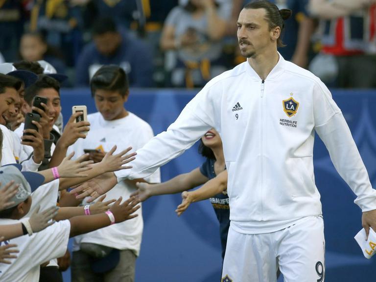 Zlatan Ibrahimovic wird von einer Gruppe junger Fans belagert.