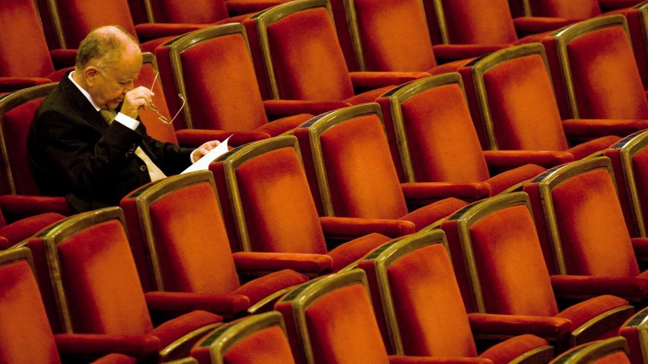 Ein Mann sitzt im Zuschauersaal der Semperoper in Dresden und wartet auf das Antrittskonzert von Christian Thielemann.