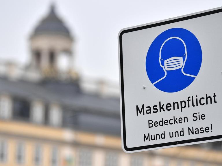 Ein Schild weist auf die Maskenpflicht in der Innenstadt hin