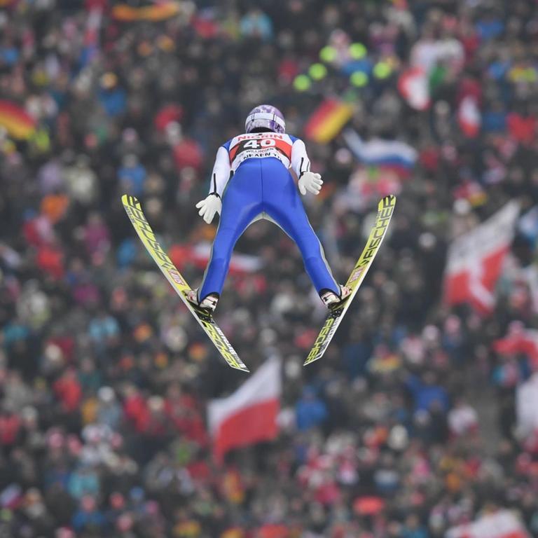 Andreas Wellinger springt von der Großschanze in Willingen (Hessen). Im Hintergrund ist das Publikum zu sehen. 