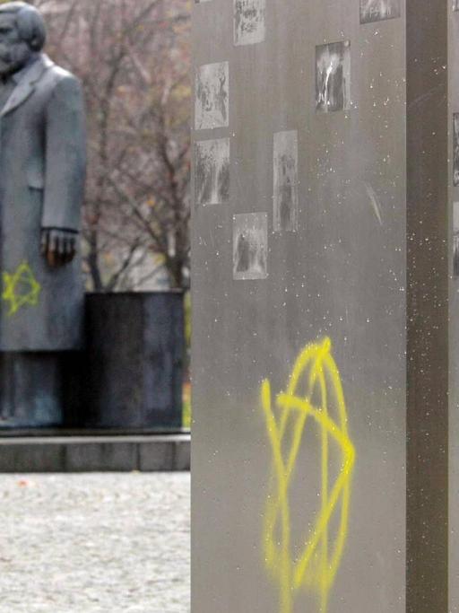 Zwei gelbe Davidsterne sind an eine Stele am Marx-Engels-Forum in Berlin geschmiert