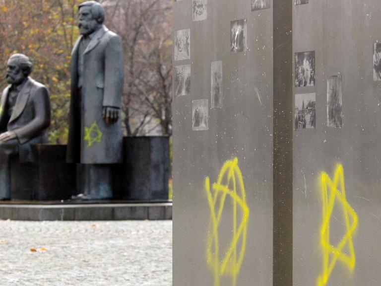 Zwei gelbe Davidsterne sind an eine Stele am Marx-Engels-Forum in Berlin geschmiert