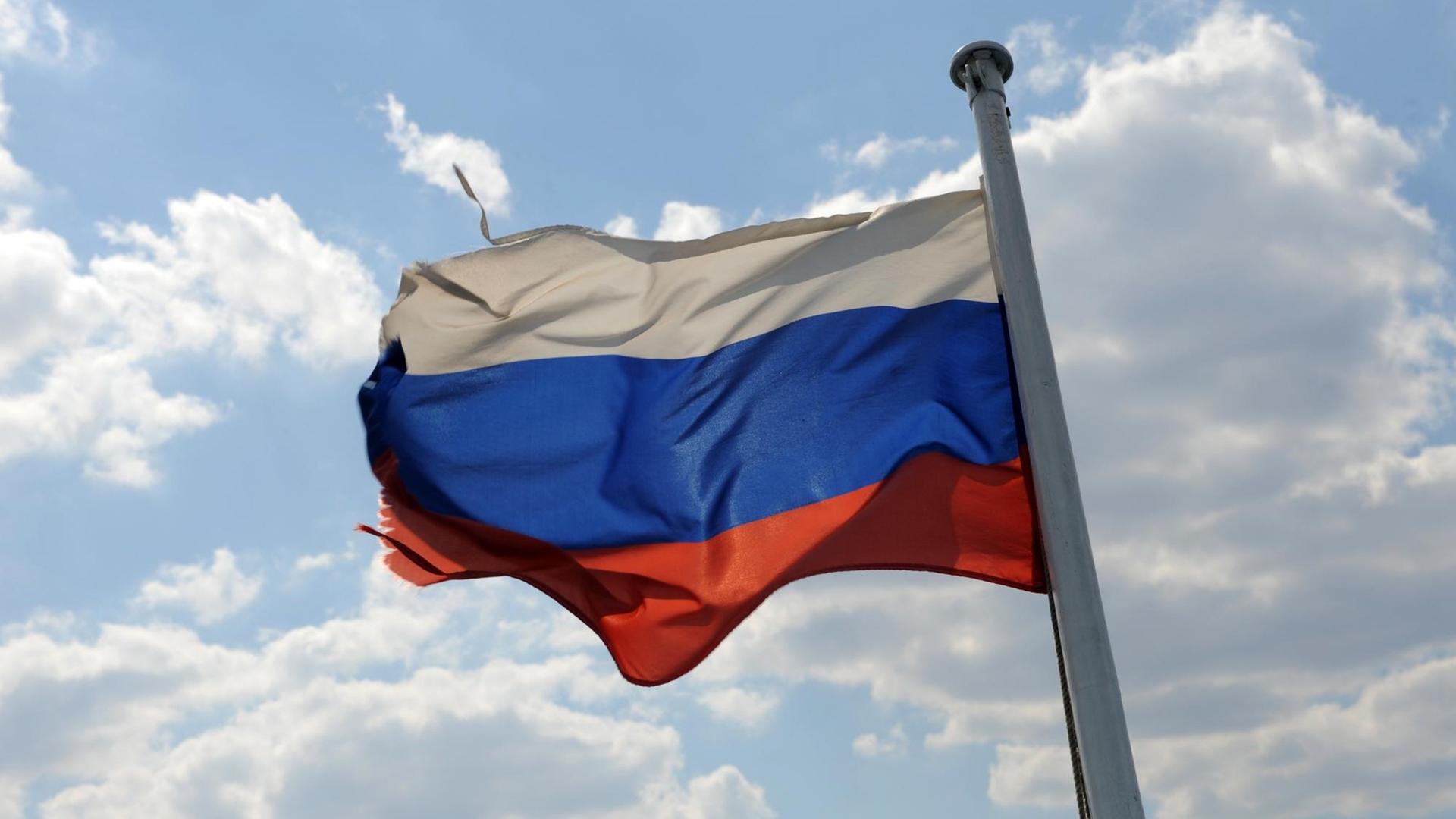 Eine leicht zerzauste russische Fahne weht in Wolgograd vor einem heiteren HImmel