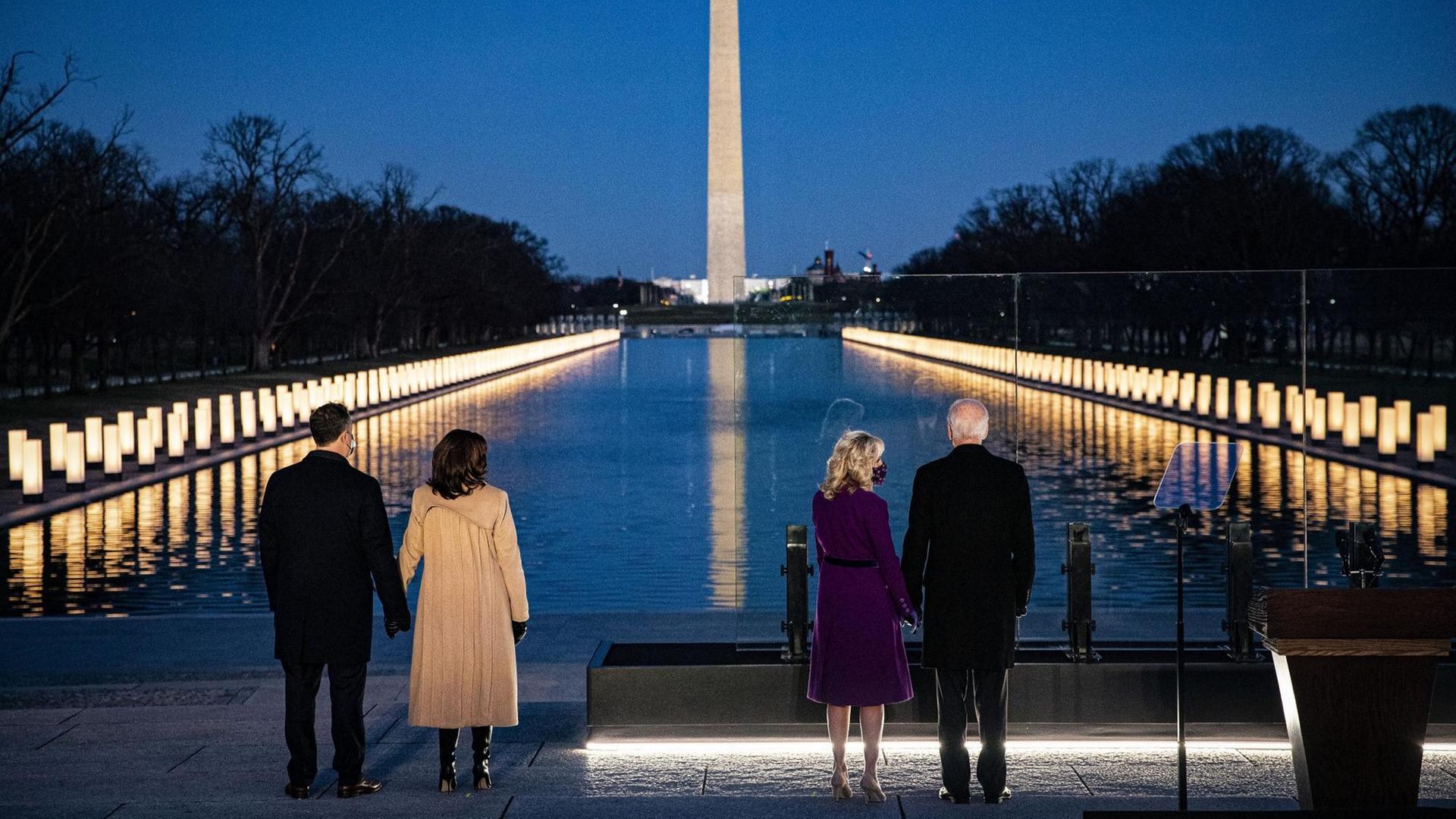 Der gewählte US-Präsident Joe Biden und seine Frau Jill und Vize-Präsidentin Kamala Harris mit ihrem Ehemann Douglas Emhoff stehen abends am von Lichtern erleuchteten Lincoln Memorial.