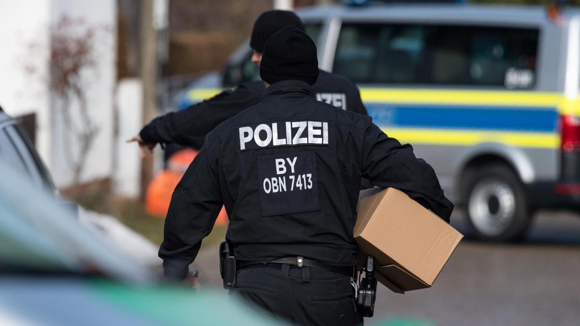 Polizisten tragen am 07.02.2017 Kartons vor einem Wohnhaus in Pliening (Bayern). In dem Haus hat zuvor ein SEK-Einsatz gegen einen Reichsbürger stattgefunden.