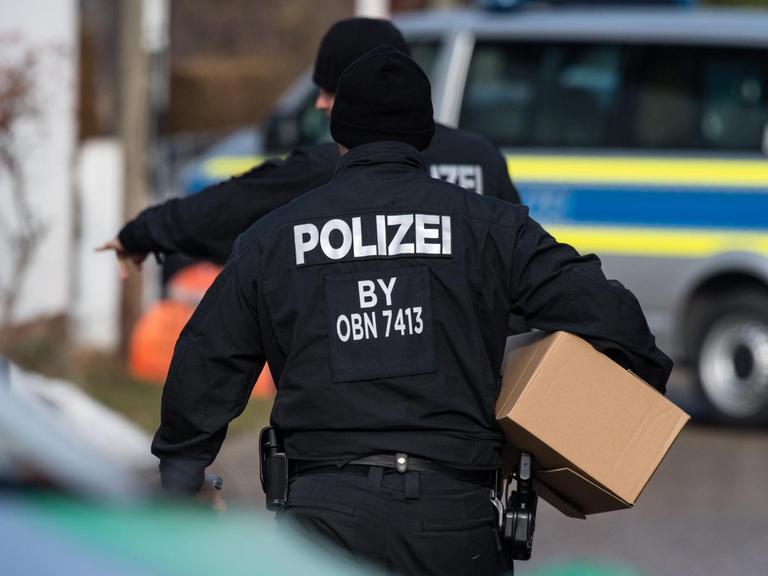 Polizisten tragen am 07.02.2017 Kartons vor einem Wohnhaus in Pliening (Bayern). In dem Haus hat zuvor ein SEK-Einsatz gegen einen Reichsbürger stattgefunden.