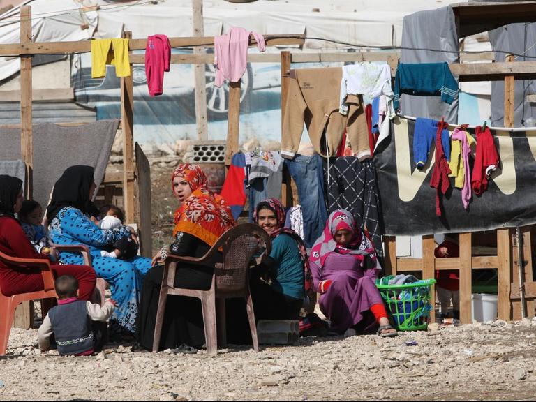 Frauen sitzen am 10.11.2015 im Libanon in der Bekaa Ebene in einem Flüchtlingslager vor ihren Behausungen. Die zumeist syrischen Flüchtlinge aus der Region