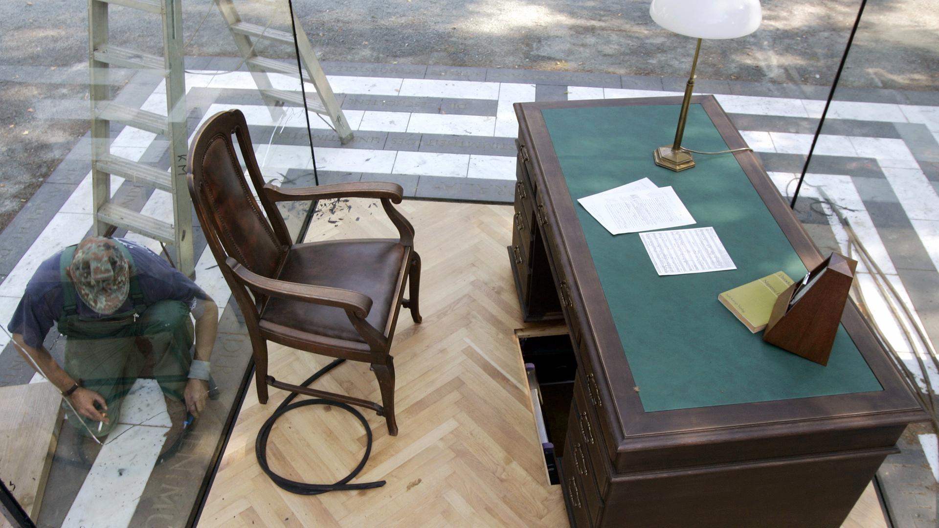 Ein Mitarbeiter einer Verglasungsfirma entfernt am Dienstag (12.07.2005) am Denkmal des ehemaligen Arbeitszimmers von Theodor W. Adorno im Frankfurter Stadtteil Bockenheim die Dichtungen der Glasscheiben, die um das Denkmal gebaut wurden. Das Kunstwerk, das bereits dreimal durch Vandalismuss zerstört wurde, soll am Abend mit einer Wiederherstellungs-Feier unter dem Titel "A night with Adorno" erneut zur Schau gestellt werden.