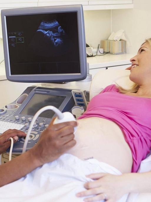 Schwangeres Paar bei der Ultraschalluntersuchung