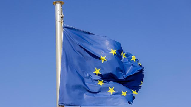 Eine zerrissene EU-Fahne flattert am Fahnenmast.