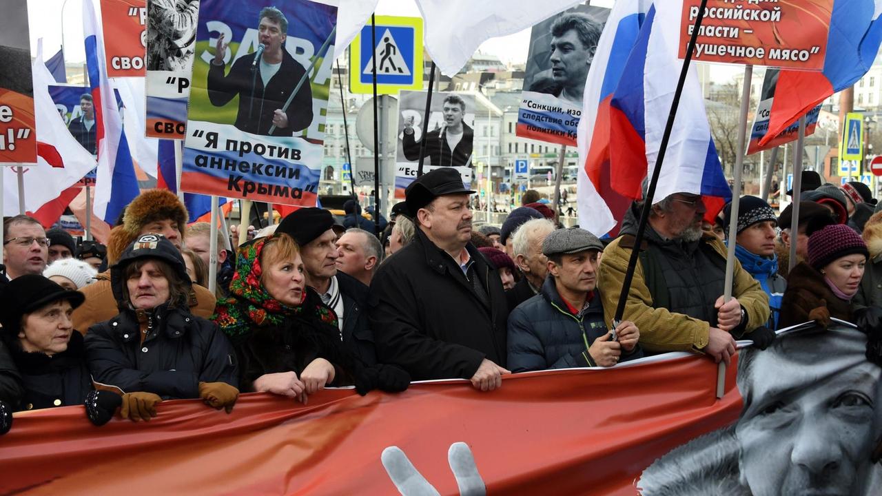 Der Anfang eines Demonstrationzuges - die Menschen tragen Banner, Plakate und Bilder Nemzows.