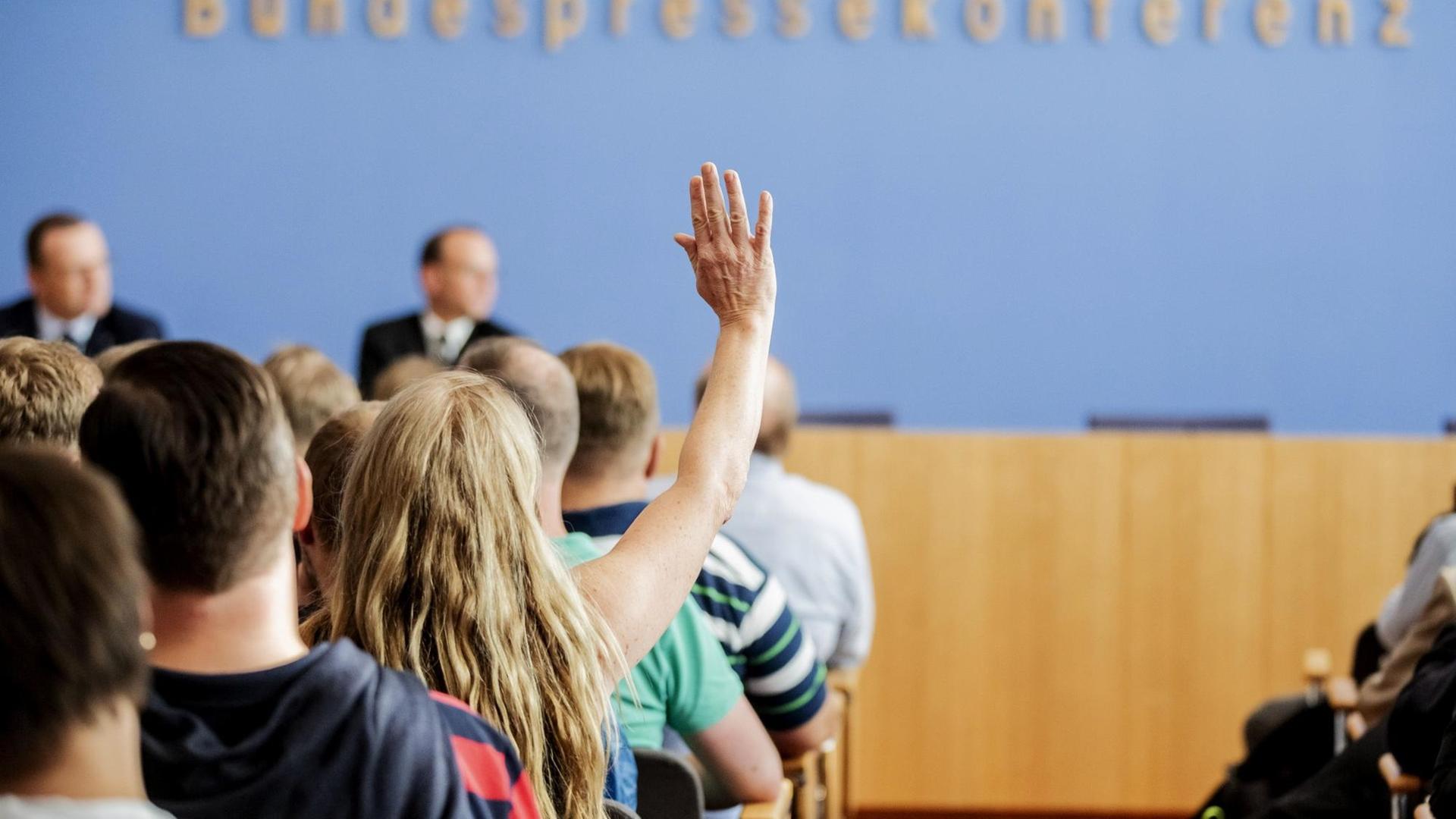 26.08.2018, Berlin: Eine Besucherin meldet sich für eine Frage an Bundesgesundheitsminister Jens Spahn (CDU) beim Tag der offenen Tür der Bundesregierung in der Bundespressekonferenz