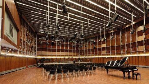 Blick in den leeren Kammermusiksaal des Deutschlandfunks: Ein großer Raum mit Parkett ausgelegt, darauf Stuhlreihen und davor ein Konzertflügel