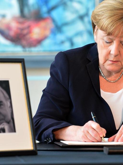 Bundeskanzlerin Angela Merkel (CDU) trägt sich am 18.06.2017 im Bundeskanzleramt in Berlin in das Kondolenzbuch für den ehemaligen Bundeskanzler Helmut Kohl ein.
