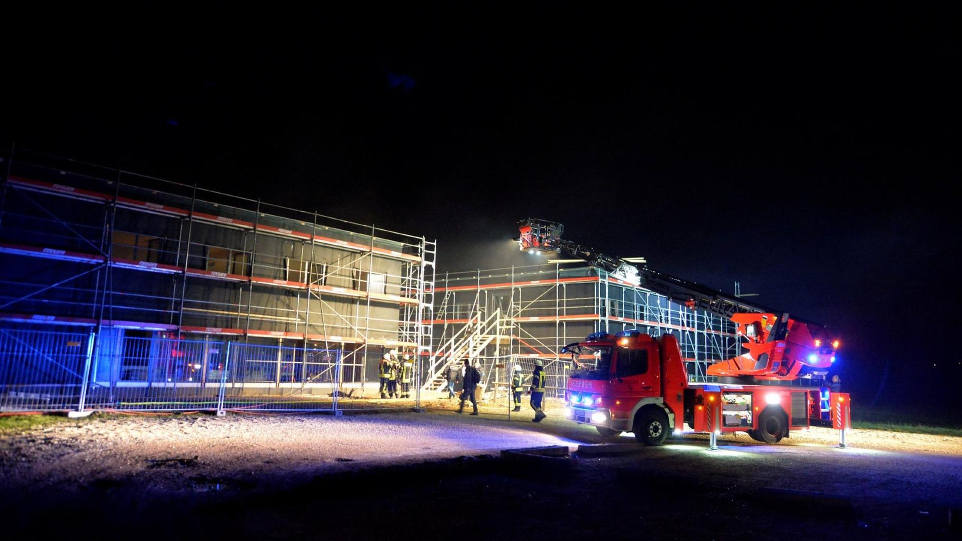Die Feuerwehr ist am 25.12.2015 im Einsatz an einer im Bau befindlichen Flüchtlingsunterkunft in Schwäbisch Gmünd (Baden-Württemberg). Die Ermittler gehen davon aus, dass das Feuer gelegt wurde, wie Polizei und Stadtverwaltung mitteilten. Das Gebäude sollte im Frühjahr fertiggestellt werden und bis zu 120 Flüchtlinge beherbergen. Das Feuer habe nur geringen Schaden angerichtet.