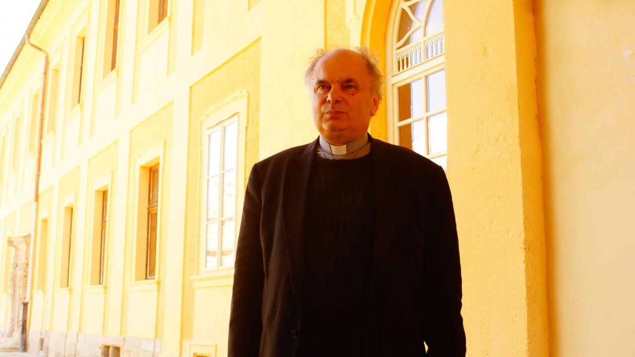 Pater Filip Lobkowicz steht vor der gelben Fassade seines Klosters in Tepla.