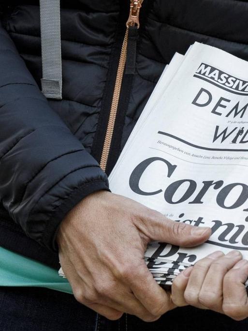 Demonstration gegen Corona-beschränkungen: Ein Demonstrant hält eine Zeitung des "Demokratischen Widerstands 2020"