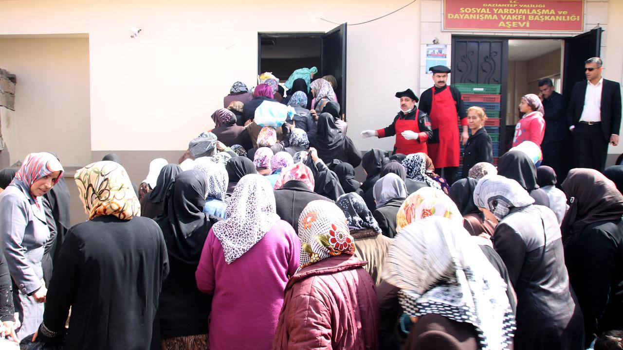 Syrische Frauen, die übrigens nach den Männern dran waren, warten am 04.03.2015 vor der Essensausgabe im Flüchtlingslager im türkischen Gaziantep. Die Syrer in der Türkei sind dem Bürgerkrieg entkommen, und ihr Gastland versucht nach Kräften, ihnen zu helfen. Trotzdem ist die Lage der Flüchtlinge hoffnungslos. Foto: Can Merey/dpa)(Zum Jahrestag des Beginns des Aufstands gegen 