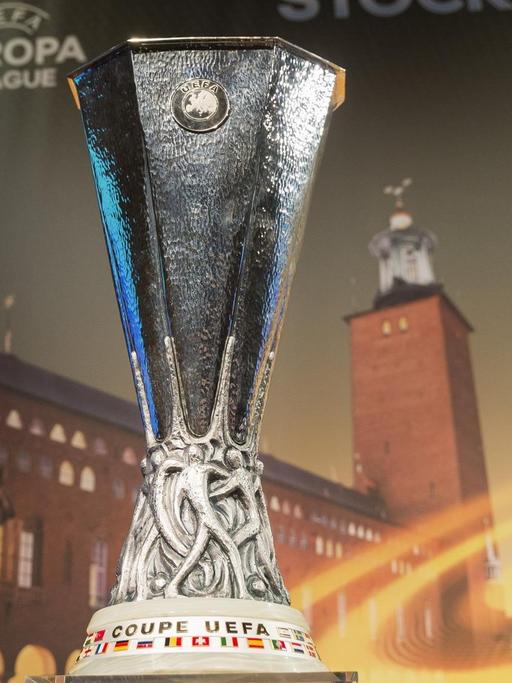 Der Pokal der Europa League vor einem Bild mit dem Logo der Europa League.