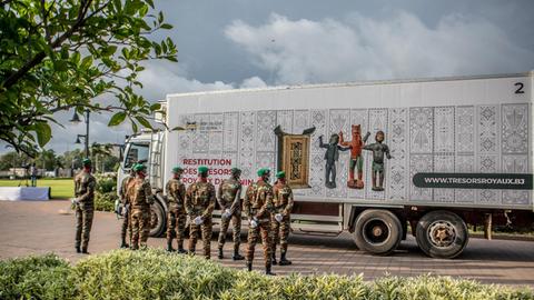 Ein Lastwagen mit den Artefakten wird von Soldaten in Benin bewacht