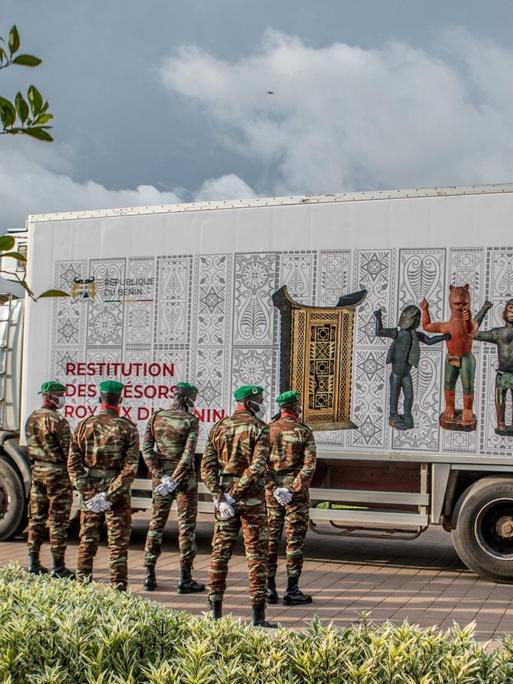 Ein Lastwagen mit den Artefakten wird von Soldaten in Benin bewacht