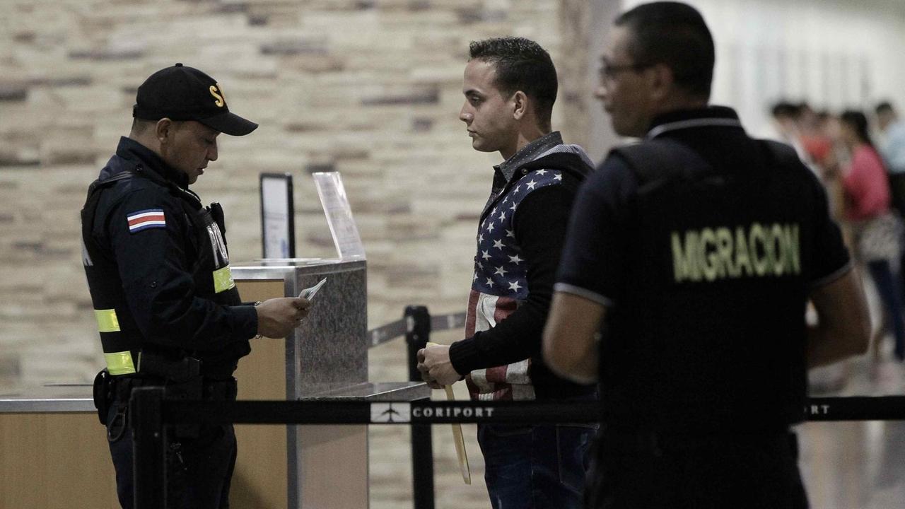 Polizisten aus Costa Rica kontrollieren die Papiere eines Flüchtlings aus Kuba, der in die USA weiterreisen will.
