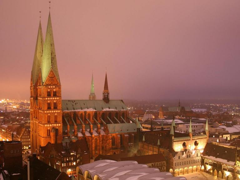 Eine Backsteinkirche mit zwei Türmen steht im nebeligen Abendlicht.