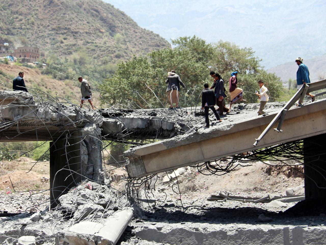 Yemenis stand on a bridge allegedly hit by an airstrike carried out by the Saudi-led coalition near the central city of Ibb, Yemen, 21 April 2015.