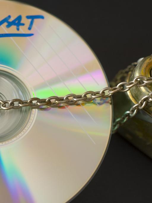 Das gestellte Illustrationsfoto zeigt einen Stapel CD, deren Gebrauch mit einer Kette und einem Vorhängeschloss geschützt ist.