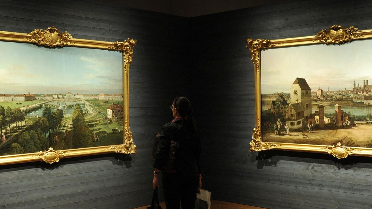 Eine Besucherin betrachtet in München in der Alten Pinakothek in der Ausstellung «Canaletto. Bernardo Bellotto malt Europa» die Bilder "Das Schloss Nymphenburg von der Stadtseite" (l, München 1761) und "München von Osten" (r, 1761).