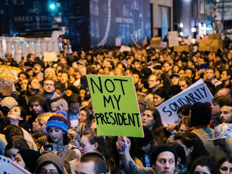 Menschen nehmen an einer Demonstration gegen den zukünftigen Präsidenten der USA, Donald Trump, in New York teil.