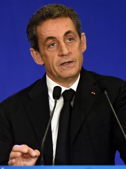 Nicolas Sarcozy steht hinter einem Rednerpult, dahinter eine französische und eine EU-Flagge.