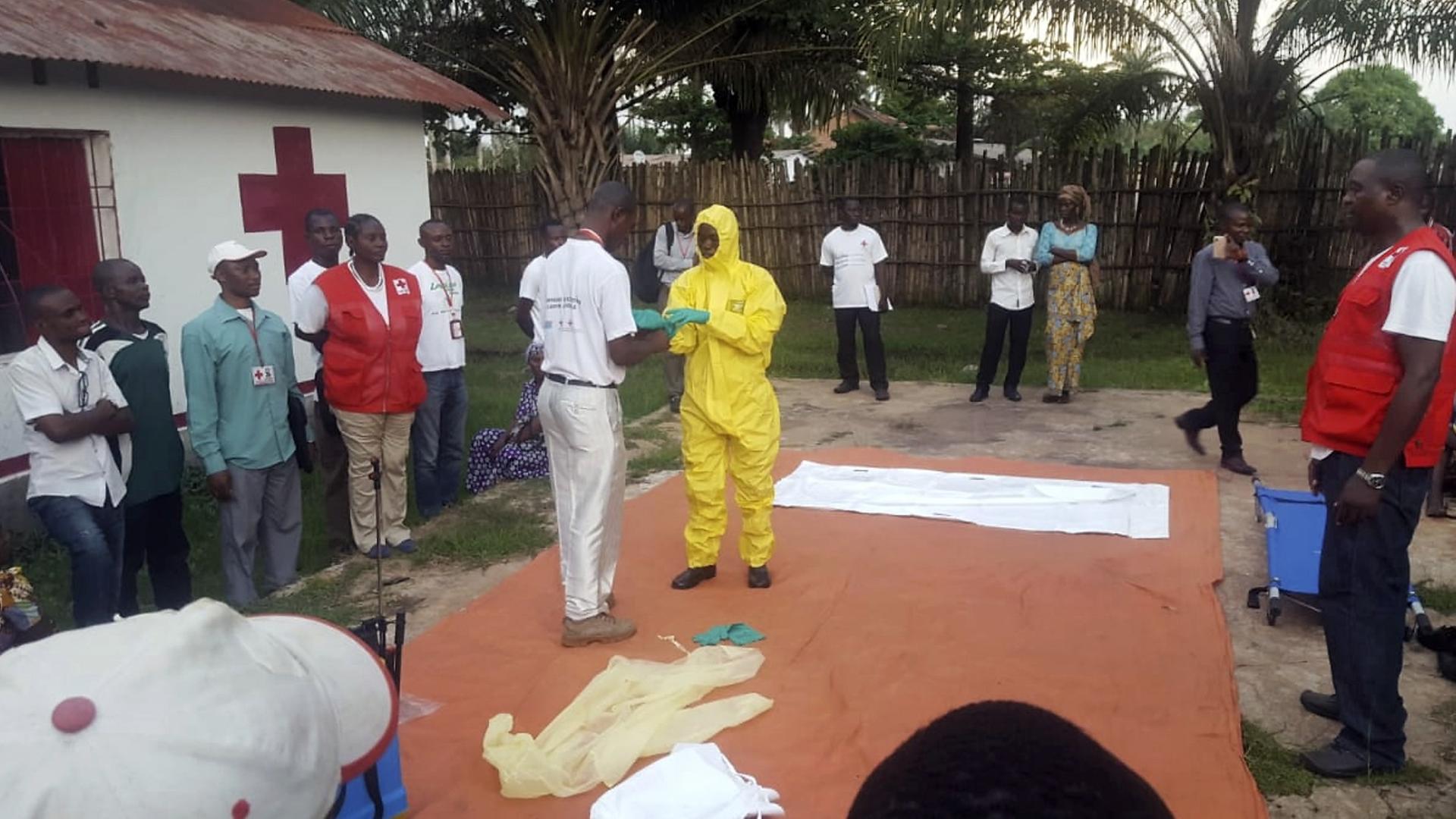 Mitarbeiter vom Roten Kreuz ziehen im Vorfeld der Suche nach Infizierten des Ebola-Virus Schutzkleidung an (14.5.2018).