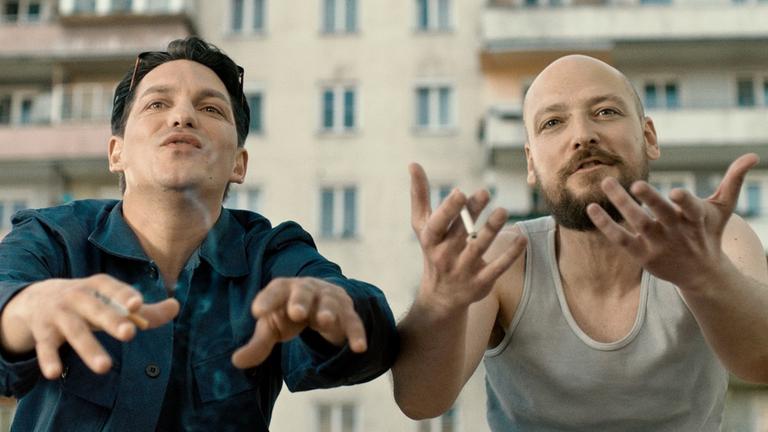 Benny (Faris Rahoma) und Marko (Aleksandar Petrovic) gestikulieren wild in einer Filmszene aus "Die Migrantigen"