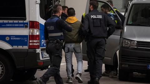 Polizisten bringen einen jungen Afghanen mit Hand- und Fußfesseln zum Frankfurter Flughafen. Nach den Vorfällen in Amberg entbrennt wieder die Debatte über die schnellere Abschiebung von Straftätern.