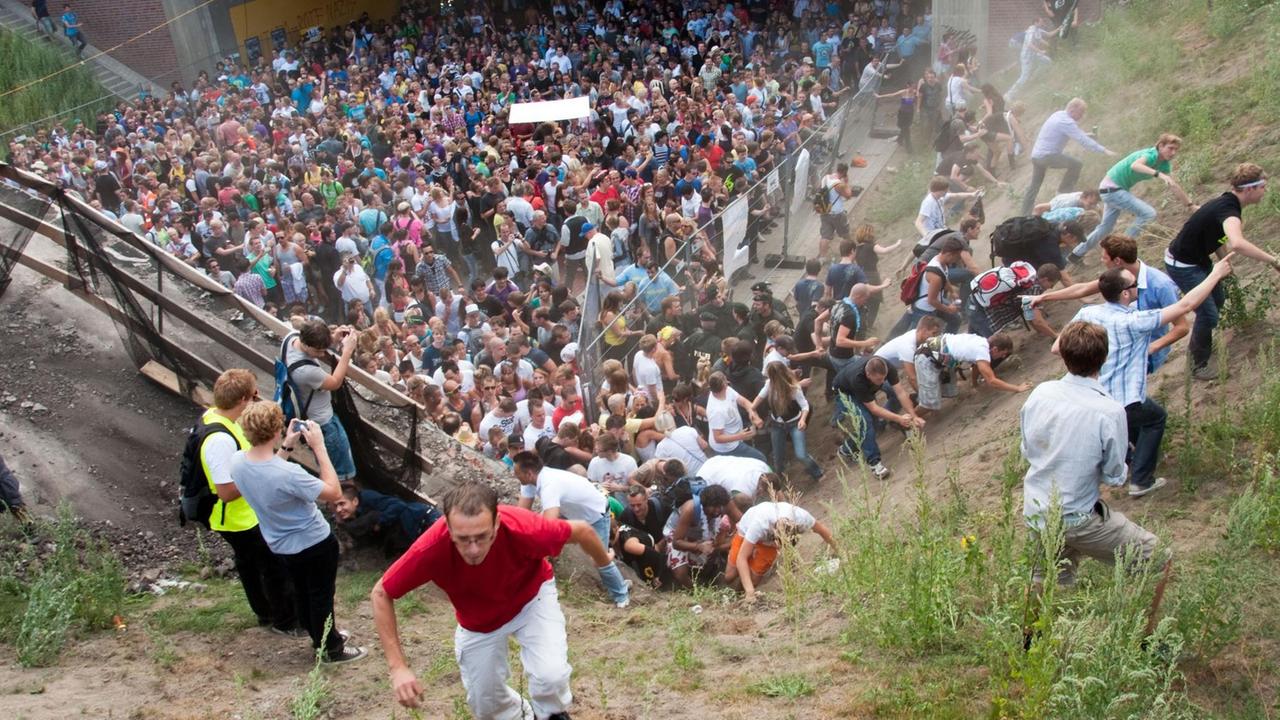 Besucher versuchen dem Gedränge bei der Loveparade am 24. Juli 2010 in Duisburg zu entkommen.