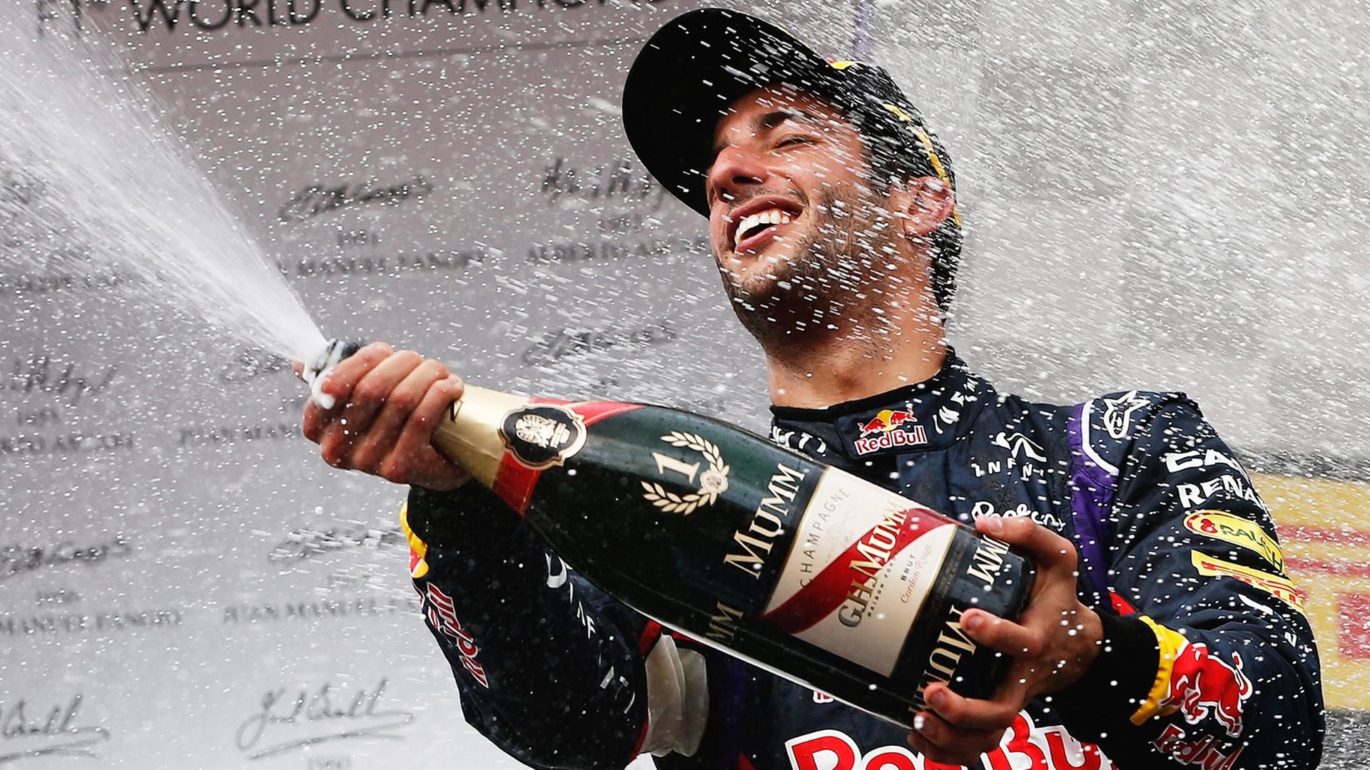 Daniel Ricciardo sprüht nach seinem Sieg Sekt aus einer riesigen Sektflasche.