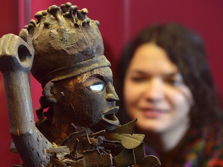 Eine Besucherin des Grassi Museums für Völkerkunde in Leipzig betrachtet am eine sogenannte Minkisi-Skulptur aus der umfangreichen Sammlung afrikanischer Schnitzfiguren mit geheimnisvollen Kräften