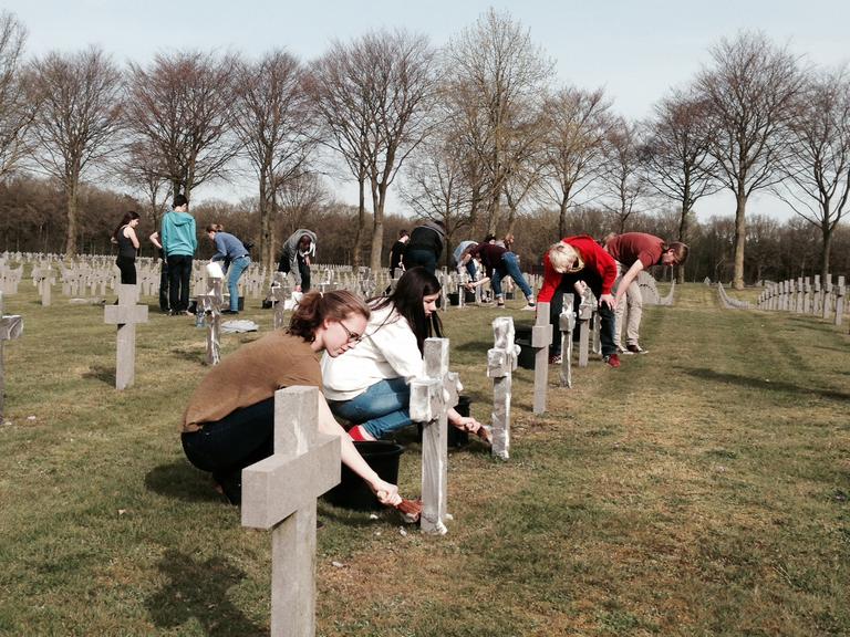 Schüler kümmern sich um die Pflege der Soldatengräbern bei der Jugendbegegnungsstätte Ysselsteyn.