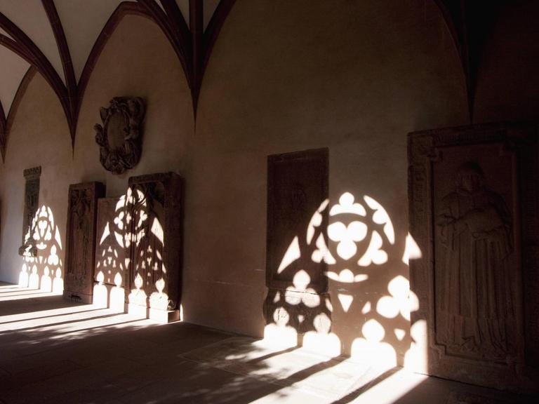 Schatten der Fensterarchitektur auf dem Boden und den Wänden des Kreuzganges.