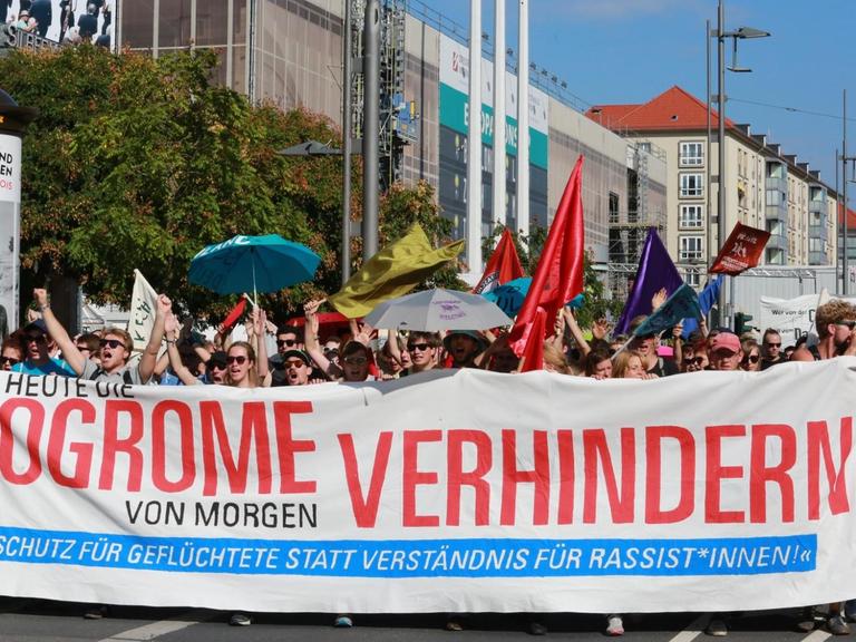 Demonstranten tragen ein Banner mit der Aufschrift: "Heute die Pogrome von morgen verhindern."