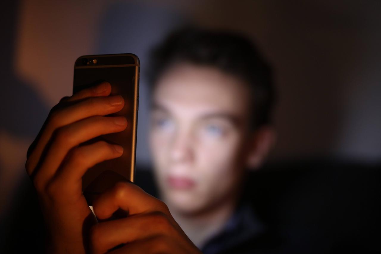 Ein Jugendlicher schaut auf sein Smartphone 