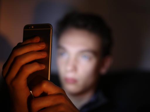 Ein Jugendlicher schaut auf sein Smartphone (Symbolbild)