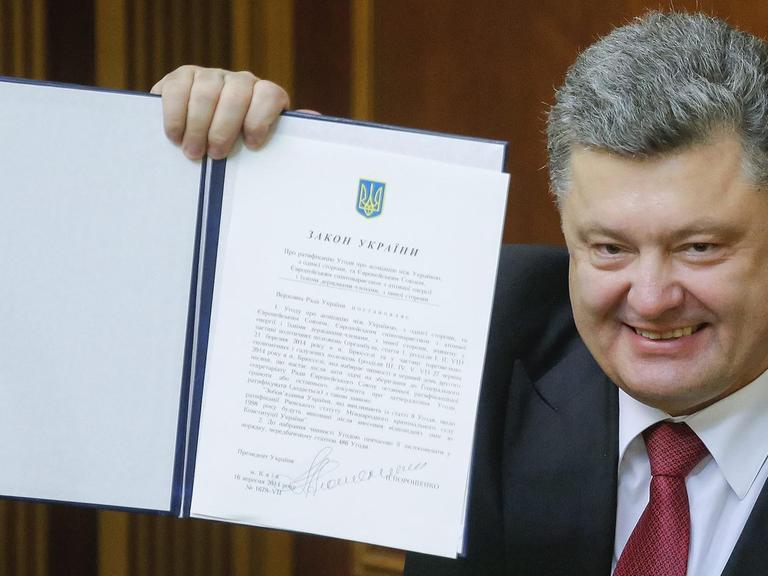 Petro Poroschenko hält das unterzeichnete EU-Partnerschaftsabkommens hoch.
