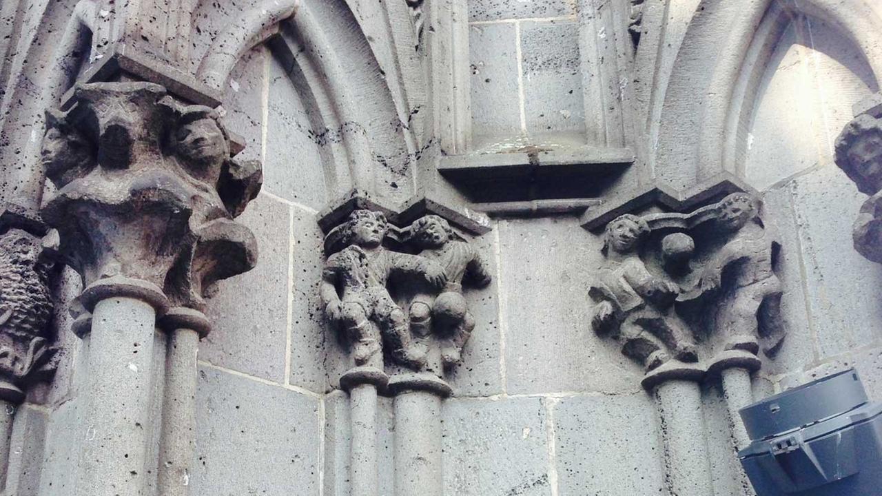Am Kölner Dom sind Fußballer-Figuren angebracht.