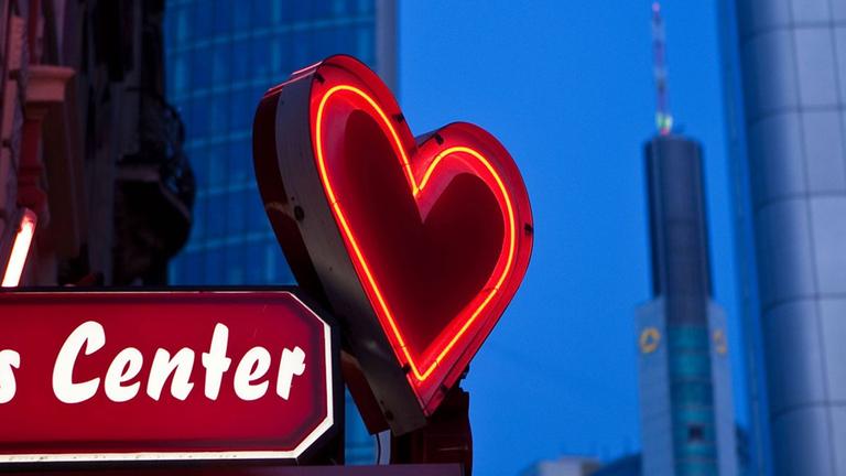 Leuchtreklame eines Prostitutionsbetriebs. Neben dem Schriftzug leuchtet ein rotes Herz. Leuchtreklame eines Prostitutionsbetriebs. Neben dem Schriftzug leuchtet ein rotes Herz.