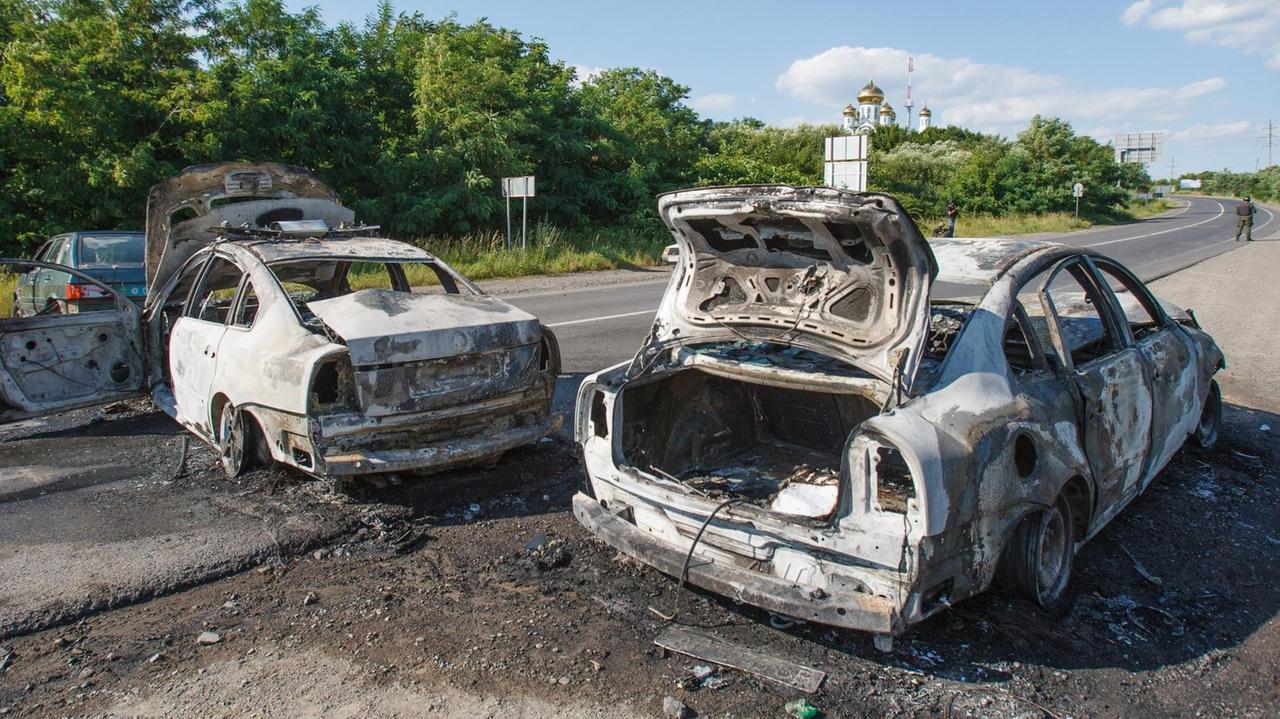 Zwei ausgebrannte Autos auf einer Straße Richtung Mukachewe im Südwesten der Ukraine.